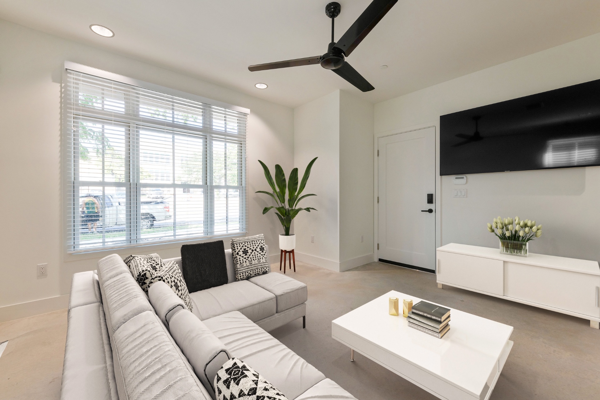 Unit 1-1 living room with sectional and mounted TV
